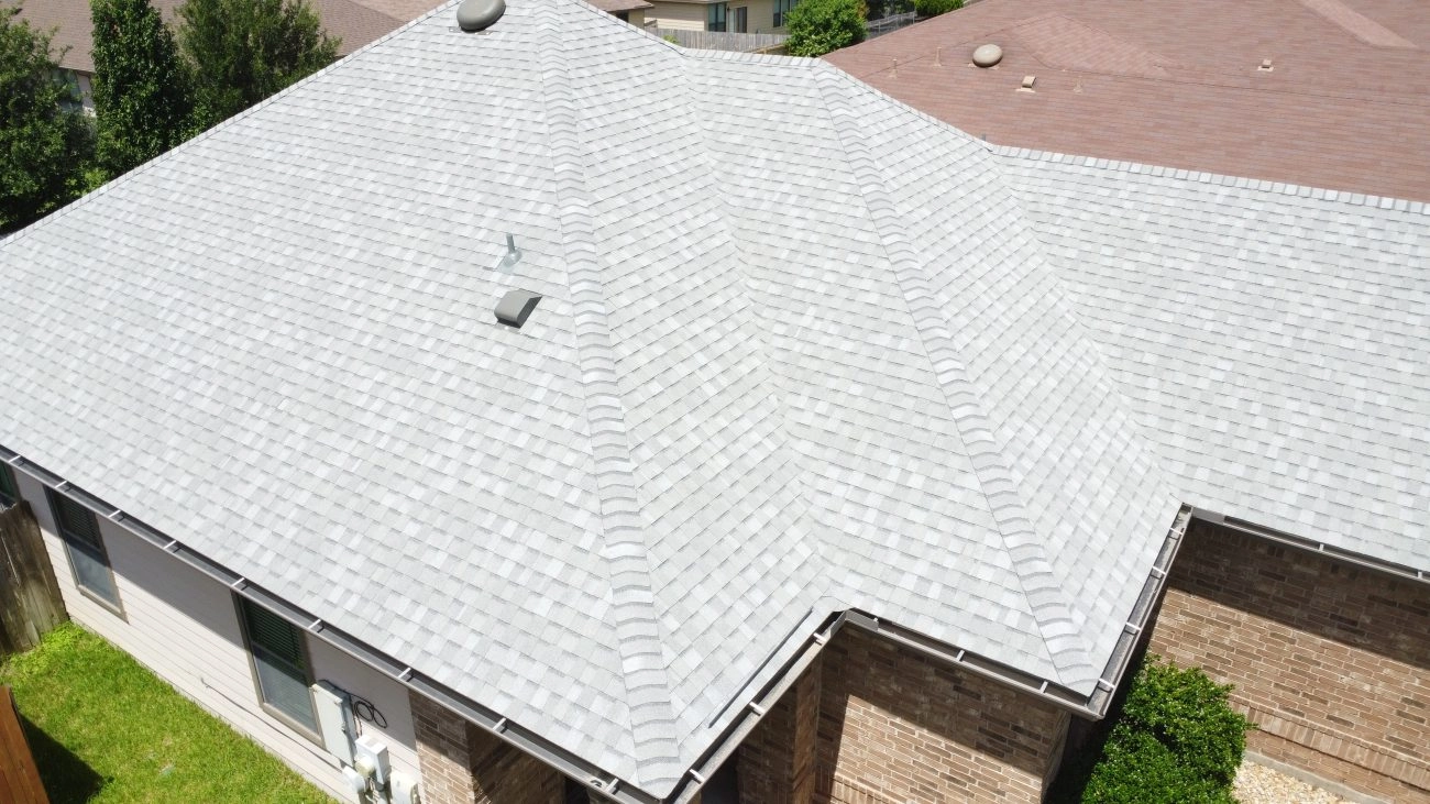 Drone view of roofing project showcasing completed shingles and structure